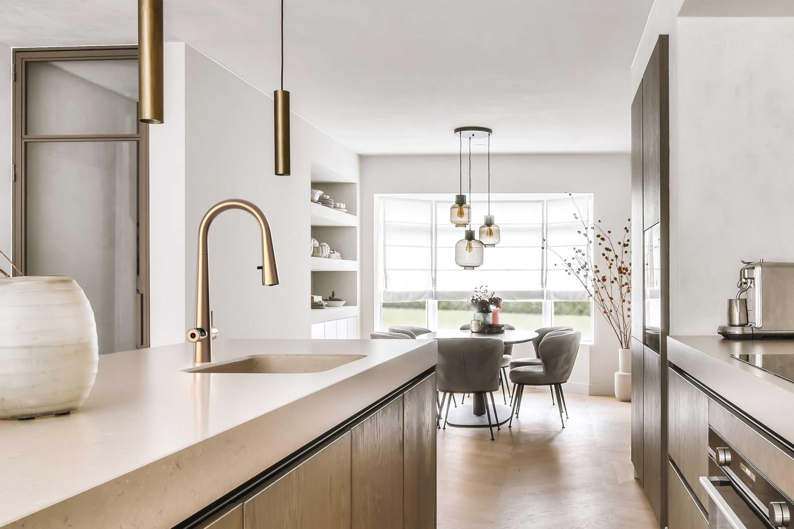 Interior of modern spacious kitchen with built in appliances and dining zone